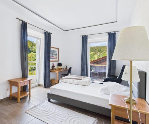 a bedroom with a bed and a large window at VATTERSGARDEN GmbH in Viechtach