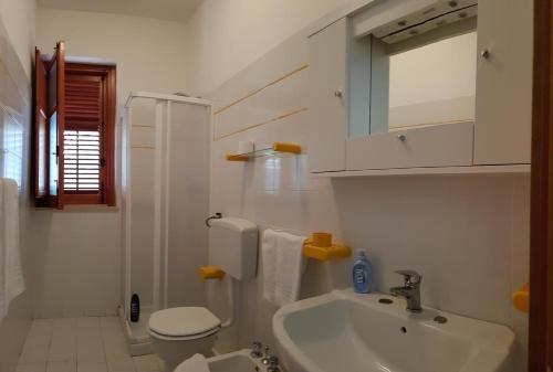 a white bathroom with a sink and a toilet at Casa Nespolo in San Vito lo Capo