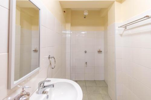 a white bathroom with a sink and a shower at Caramel Studio In CBD with Free WI-FI in Nanyuki