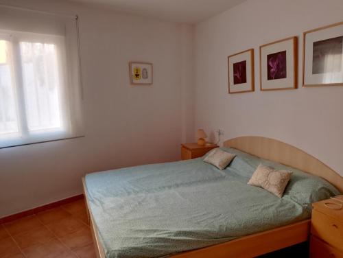 a bedroom with a bed and a window at Pescadors in Les Cases d'Alcanar