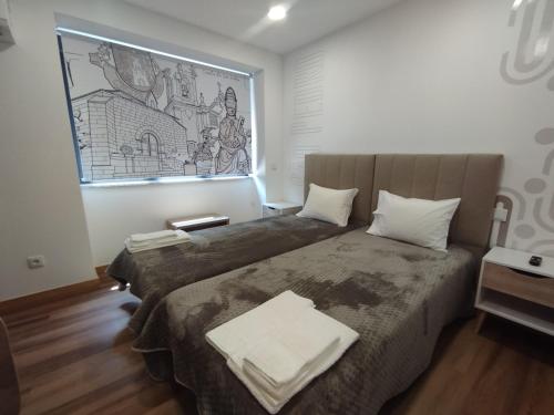 a bedroom with two beds and a painting on the wall at SeiaVilla - São Pedro in Seia