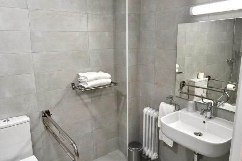 a bathroom with a sink and a toilet and a mirror at Alda Estación Pontevedra in Pontevedra