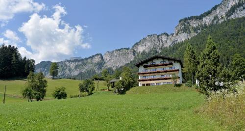 ein großes Gebäude auf einem Hügel auf einem Feld in der Unterkunft Berghof Haselsberger Appartements in Sankt Johann in Tirol