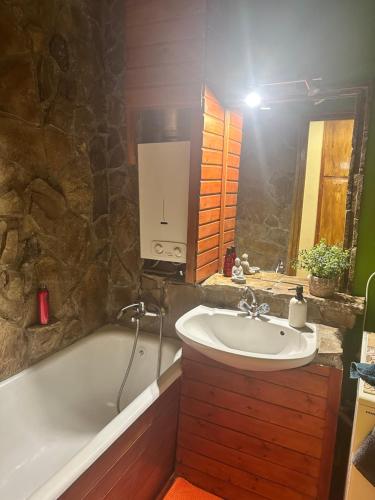 a bathroom with a bath tub and a sink at Casa Siesta apartman in Makó
