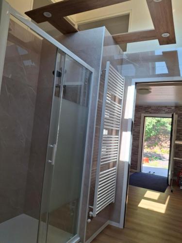 a bathroom with a shower with a glass door at NORDIQUES DE LA WELCHE in Orbey