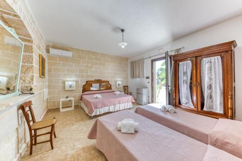 a hotel room with two beds and a bathroom at Masseria Prisuti in Punta Prosciutto