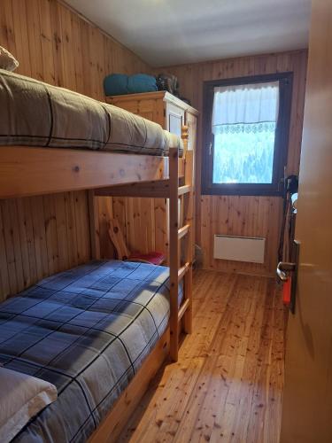 a bedroom with two bunk beds and a window at Dolomites View Apartment - Mountain Relax Experience in Cibiana