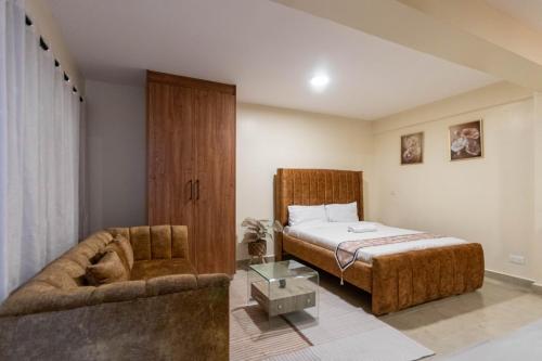 a bedroom with a bed and a couch at Rustic Studio in CBD with free WI-FI in Nanyuki