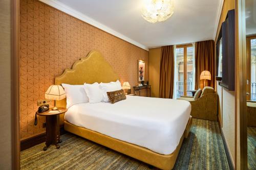 a hotel room with a large bed and a chair at Hotel España Ocean Drive - Newly Renovated in Barcelona