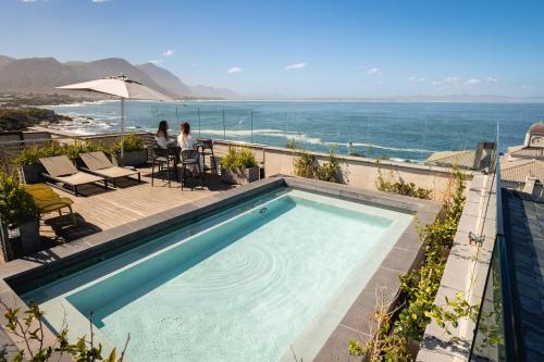 a swimming pool with a view of the ocean at Hermanus Waterfront Apartments in Hermanus