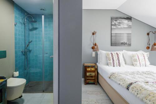 a bedroom with a king sized bed and a shower at Casa da Praça - Alojamento Local in Sesimbra