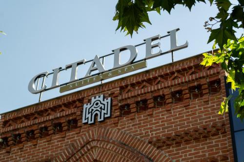 ein Schild auf einem Backsteingebäude in der Unterkunft Citadel 360 Suites & Spa in Skopje
