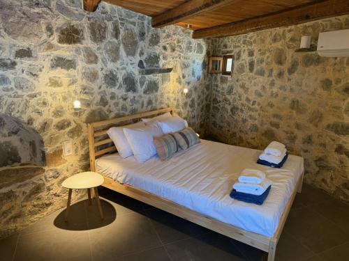 a bedroom with a bed with two towels on it at Stone Villa, Infinity Pool & Libyan Sea Views in Agia Galini