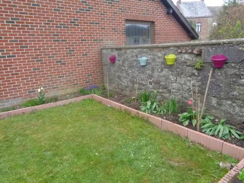 a garden with a brick wall and some plants at Apartment Philippeville 18 m² Garden in Philippeville