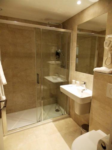 une salle de bain avec douche et lavabo dans l'établissement Excelsior Batignolles, à Paris