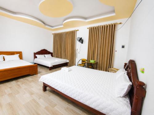a bedroom with two beds and a table at Linh Chi Hotel in Mù Cang Chải