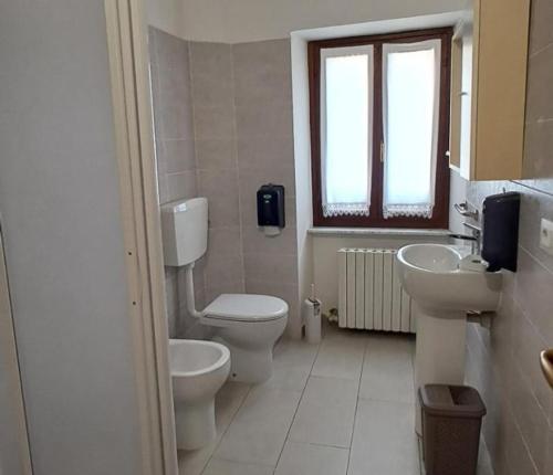 a bathroom with two toilets and a sink and a window at Desdemona House Pub in Castellino Tanaro