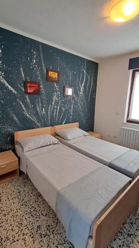 two twin beds in a room with a wall withhazard at Desdemona House Pub in Castellino Tanaro