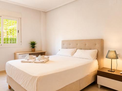 a bedroom with a large white bed with towels on it at Villa La Perla - Pool, Garden & Barbecue - AC in Mutxamel