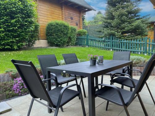 a black table and chairs on a patio at Der Fuchsbau - 3 separate Blockhäuser - ruhige Lage - 50m bis zum Wald - eingezäunter Garten in Bad Sachsa