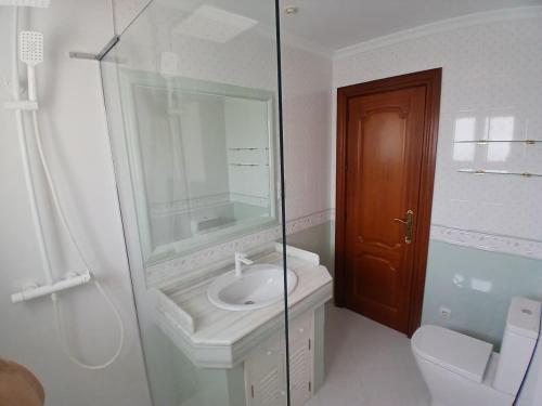 a bathroom with a sink and a glass shower at Casa Lunamar in Rincón de la Victoria