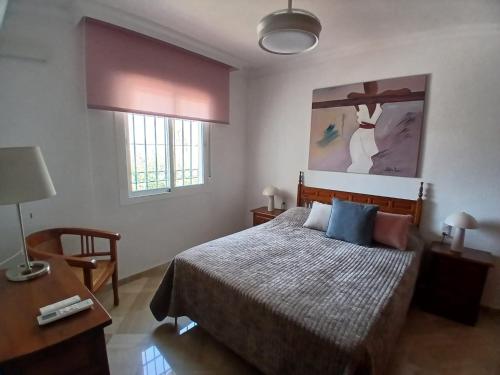 a bedroom with a bed and a table with a lamp at Casa Lunamar in Rincón de la Victoria