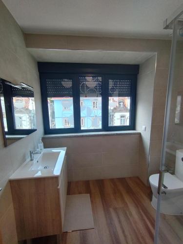 a bathroom with a sink and a toilet and a window at SeiaVilla - 4 Fontes in Seia