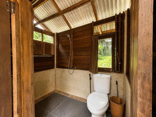 a bathroom with a toilet and a window at Indigo Homestay in Ban Huai Pong
