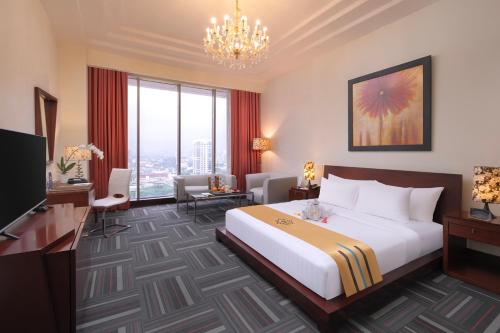 a hotel room with a large bed and a chandelier at Merlynn Park Hotel in Jakarta