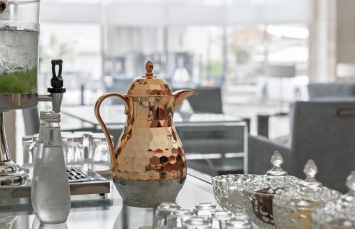 a tea kettle on a table with a glass bowl at Park Inn by Radisson Al Khobar in Al Khobar