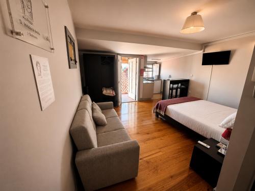 a living room with a couch and a bed at Guest House Vimaranes in Guimarães