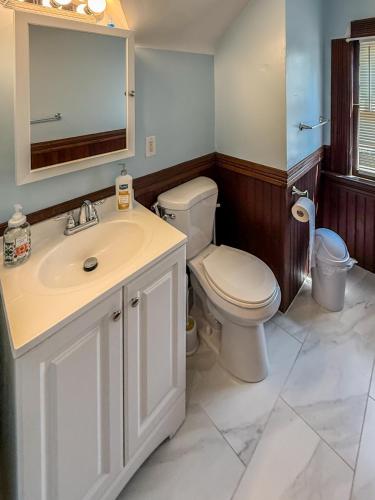 a bathroom with a toilet and a sink and a mirror at YLD Rooms - Shared Bathrooms & Spaces in Springfield