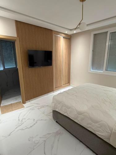 a bedroom with a bed and a flat screen tv at appartement de luxe tanger in Tangier
