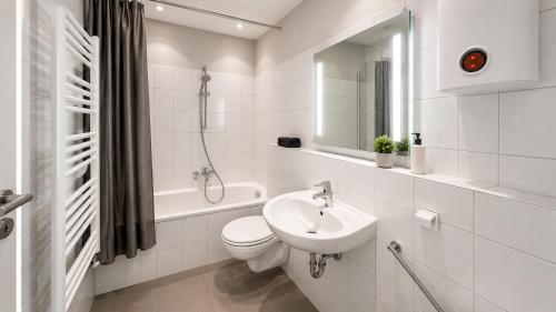 a white bathroom with a toilet and a sink at Pulheim Living 3 in Pulheim