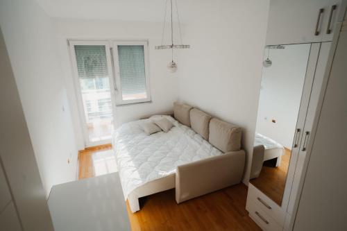 a white room with a couch and a window at The Red Lounge in Strumica