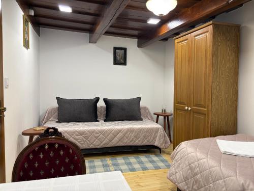 a bedroom with two beds and a wooden cabinet at Hajnal Vendégház in Kéked