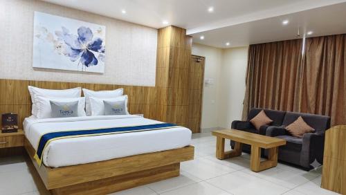 a bedroom with a large bed and a chair at Hotel Teesta Stay, Rampurhat in Tarapith