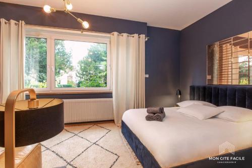 a bedroom with a large bed and a window at La VILLA du Reims - Mon Gîte Facile in Colmar