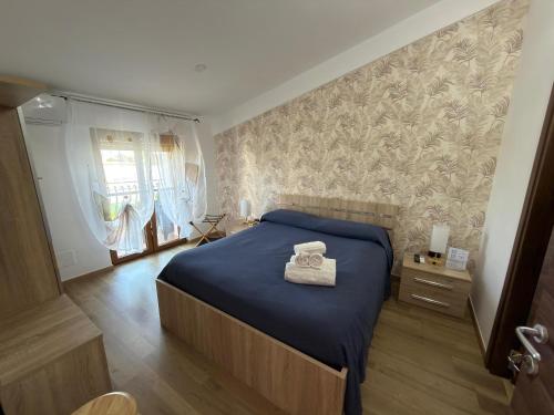 a bedroom with a bed with a blue blanket and a window at Villa Anté B&B in Angri