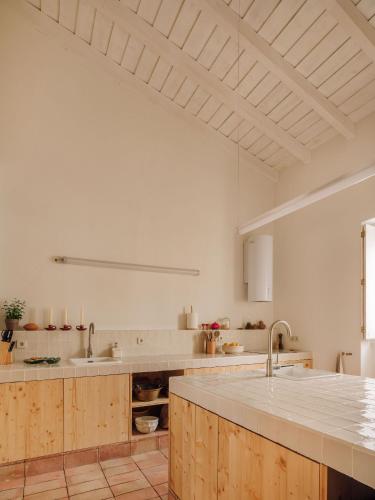 a large kitchen with wooden cabinets and a sink at Casa Dez - Pedrogão do Alentejo in Pedrógão