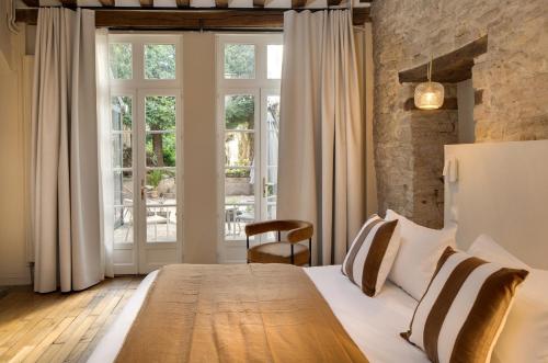 a bedroom with a large bed and a large window at Hôtel des Ducs in Dijon