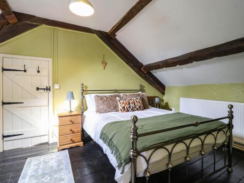a bedroom with a bed and a green wall at Frondirion in Machynlleth