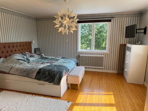 a bedroom with a bed and a chandelier at Villa Oakfield in Fröseke