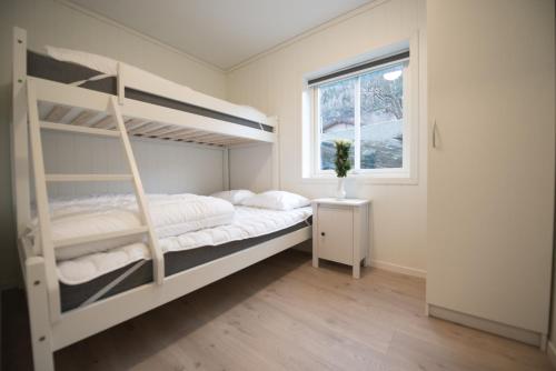 a bedroom with two bunk beds and a window at Lofthus Camping in Lofthus