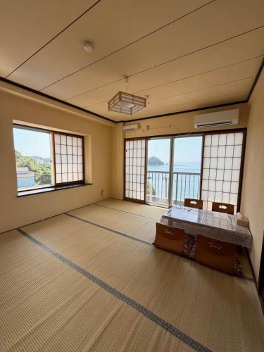 a large room with a bed and large windows at 島の宿 in Toba