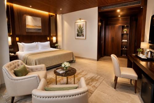 a hotel room with a bed and a table and chairs at Ananta Express Jaunpur in Jaunpur