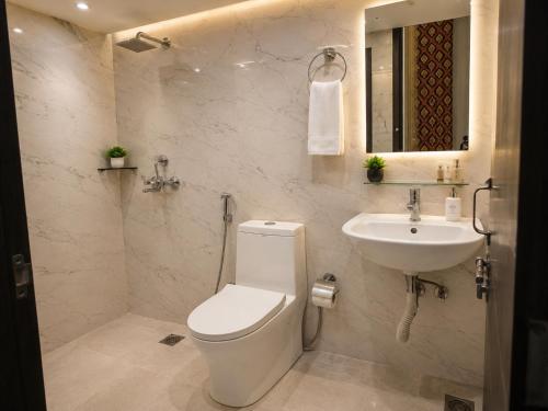 a white bathroom with a toilet and a sink at Hotel The Montana Suite - Free Airport and Aerocity Pickup & Drop in New Delhi