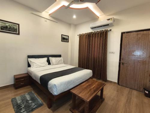 a bedroom with a large bed and a wooden table at Rayta Aravalli View Villa in Udaipur