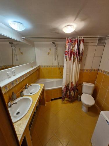 a bathroom with two sinks and a tub and a toilet at LV Central Apartment in Levice