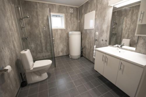 uma casa de banho com um WC, um chuveiro e um lavatório. em Lofthus Camping em Lofthus